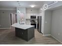 Open kitchen featuring white cabinets, stainless appliances, a center island with quartz countertop, and stylish lighting at 3428 Soho St # 208, Orlando, FL 32835