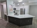 Modern kitchen with white cabinetry, stainless steel appliances, and a center island topped with quartz countertops at 3428 Soho St # 208, Orlando, FL 32835
