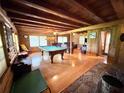 Expansive living room with a pool table, hardwood floors, a stone fireplace, and ample seating at 4075 Packard Ave, St Cloud, FL 34772