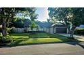 Inviting single-story home with lush green lawn, mature trees, and well-maintained landscaping at 4830 Red Bay Dr, Orlando, FL 32829
