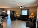 Open concept living space with tile flooring, a ceiling fan, and sliding glass doors to the outside at 5519 Braken Fern Way, Leesburg, FL 34748