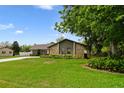 Charming single-story home featuring a stone facade, well-manicured lawn, and a long driveway at 6161 Bass Hwy, St Cloud, FL 34771