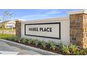 Mabel Place community entrance sign with stone pillars and manicured landscaping against a blue sky at 657 Hennepin Loop, Lake Wales, FL 33898