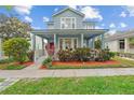 Charming two-story home featuring a welcoming front porch and lush landscaping at 6905 Beargrass Rd, Harmony, FL 34773