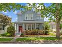 Charming two-story home featuring a welcoming front porch and lush landscaping at 6905 Beargrass Rd, Harmony, FL 34773