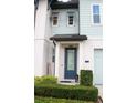Elegant front entrance with a blue door, neat landscaping, and modern exterior lighting at 721 Benoi Dr, Davenport, FL 33896