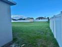 Large, well-maintained backyard enclosed by a white fence providing privacy and a shed for storage at 841 Fir Ave, Frostproof, FL 33843