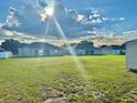 Expansive backyard featuring lush green grass and rear view of neighboring houses at 841 Fir Ave, Frostproof, FL 33843