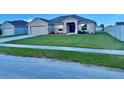 Inviting single-Gathering home boasts a well-manicured lawn, two car garage, and neatly landscaped garden beds at 841 Fir Ave, Frostproof, FL 33843