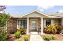 Inviting front entrance with brick facade, covered porch, manicured shrubs, and decorative potted plants at 904 Michigan Ave, St Cloud, FL 34769