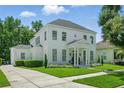 Elegant white home featuring a beautifully landscaped yard and classic architectural details at 933 Jasmine St, Celebration, FL 34747