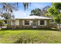 Cozy single story home featuring a metal roof, manicured lawn, and a serene outdoor setting at 1101 Oregon Ave, St Cloud, FL 34769