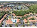 Panoramic aerial view of a residential community featuring mature trees, a pool, and scenic ponds at 1129 Park Ridge Cir, Kissimmee, FL 34746