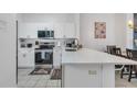 Modern kitchen features white cabinets, stainless steel appliances, quartz countertops, and tile floors at 1129 Park Ridge Cir, Kissimmee, FL 34746