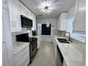 Bright white kitchen featuring modern cabinets, stainless steel appliances, and a stylish light fixture at 1211 Lehigh St, Kissimmee, FL 34744