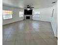 Spacious living room featuring neutral tile flooring, bright windows, and a fireplace with a decorative mantle at 1211 Lehigh St, Kissimmee, FL 34744
