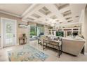 Beautiful living room with coffered ceilings, built-in shelving, tile floors, and access to the backyard at 1225 Radiant St, Reunion, FL 34747
