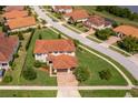 Aerial view of a well-maintained home with a red tile roof and a lush green lawn in a quiet neighborhood at 1776 Bella Lago Dr, Clermont, FL 34711