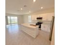 Modern kitchen featuring an island, stainless steel appliances and sliding glass doors to the patio at 2278 Tay Wes Dr, St Cloud, FL 34771