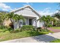 Attractive single-story house with palm trees, lush plants, and a brick driveway leading to a garage at 2772 Southland St, St Cloud, FL 34772