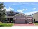 Charming two-story home with a brick driveway and stone accents, plus a three-car garage for ample parking at 2805 Carter Grove Ln, Kissimmee, FL 34741