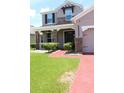Well maintained front lawn with bushes lining the brick paved walkway to the front door at 2805 Carter Grove Ln, Kissimmee, FL 34741