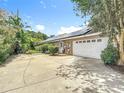 Spacious two-car garage with solar panels on the roof and a long driveway for extra parking at 3158 Forest Breeze Way, St Cloud, FL 34771