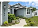 Close-up of the front of a single story home, featuring a landscaped walkway to the front door at 3390 George Sauls St, Deltona, FL 32738