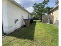 Side yard featuring a well-maintained lawn with some foliage and utilities at 343 Marquee Dr, Kissimmee, FL 34758