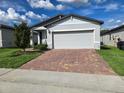 Charming single-story home with a brick driveway and attached two-car garage at 3839 Marbella Way, Davenport, FL 33897