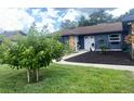Well-maintained front exterior with mature landscaping and inviting walkway to the entrance at 421 Bridle Path, Casselberry, FL 32707