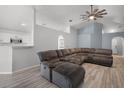 Spacious living room featuring a large sectional sofa, vaulted ceilings, and wood-look flooring at 447 Hammerstone Ave, Haines City, FL 33844