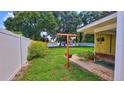 Side yard featuring a cozy swing, potted plants, and a manicured lawn at 518 Oranole Rd, Maitland, FL 32751