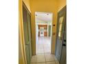 View of a tiled entryway that looks into the kitchen with wood cabinets and white appliances at 5230 Clarion Oaks Dr, Orlando, FL 32808