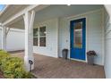 A beautiful blue front door welcomes you, framed by a covered porch and brick walkway at 6522 Rover Way, St Cloud, FL 34771