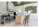 Outdoor kitchen features stone accents, stainless steel appliances and a bar area, perfect for entertaining at 9905 Lanai View Ct, Windermere, FL 34786