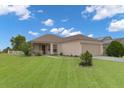 Inviting single-story home featuring a covered porch and lush green lawn at 1197 E Grove Ave, Lake Wales, FL 33853