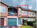 Charming condo featuring a teal garage door, screened balcony, and manicured landscaping at 12021 Villanova Dr # 111, Orlando, FL 32837