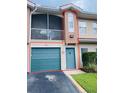 Two-story townhome featuring a garage, screened balcony, and blue entry door at 12021 Villanova Dr # 111, Orlando, FL 32837