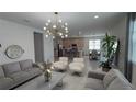 Open concept living room featuring modern lighting, neutral furniture, and seamless access to the kitchen at 2508 W End Dr, St Cloud, FL 34772