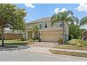 Two story home featuring a brick driveway, two car garage, well maintained lawn and manicured landscaping at 256 Yellow Snapdragon Dr, Davenport, FL 33837