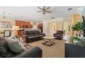 Bright living room features leather furniture, a ceiling fan and opens to a kitchen and dining area at 256 Yellow Snapdragon Dr, Davenport, FL 33837