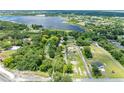 An aerial view of a property located on a tree-lined street with a lake in the background at 2571 Ames Haven Rd, Kissimmee, FL 34744
