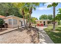 Charming cottage with palm trees, walkway, and inviting entrance, creating a relaxing and tropical curb appeal at 2571 Ames Haven Rd, Kissimmee, FL 34744