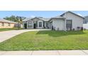 Well-maintained single-story home with lush green lawn and a basketball hoop on the driveway at 2626 Gentre St, Kissimmee, FL 34744
