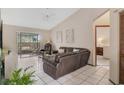 Bright living room featuring tile floors, a ceiling fan, and a sliding glass door leading to the outside at 2626 Gentre St, Kissimmee, FL 34744