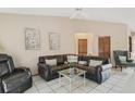 Cozy living room with tile floors, a ceiling fan, and comfortable leather furniture at 2626 Gentre St, Kissimmee, FL 34744