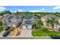 A two-story home with manicured lawns, a stone facade, and a convenient three-car garage at 2669 Sand Hill Point Cir, Davenport, FL 33837