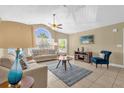 Bright living room with vaulted ceilings, tile floors, large windows, ceiling fan, and comfortable furnishings at 2737 N Poinciana Blvd # 92, Kissimmee, FL 34746