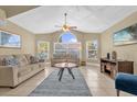Cozy living room showcasing vaulted ceilings, large windows, neutral tones, and comfortable seating arrangement at 2737 N Poinciana Blvd # 92, Kissimmee, FL 34746